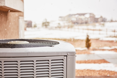 Residential air conditioning unit with snow in winter.